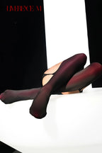 Reclining pose in Gem 150D burgundy one-piece garter stockings
