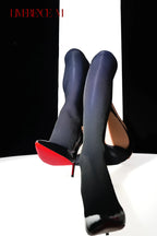 Raised legs wearing Gem 150D navy one-piece garter stockings and heels
