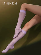 Crossed legs wearing Graceline 8D lavender plaid knee-high socks